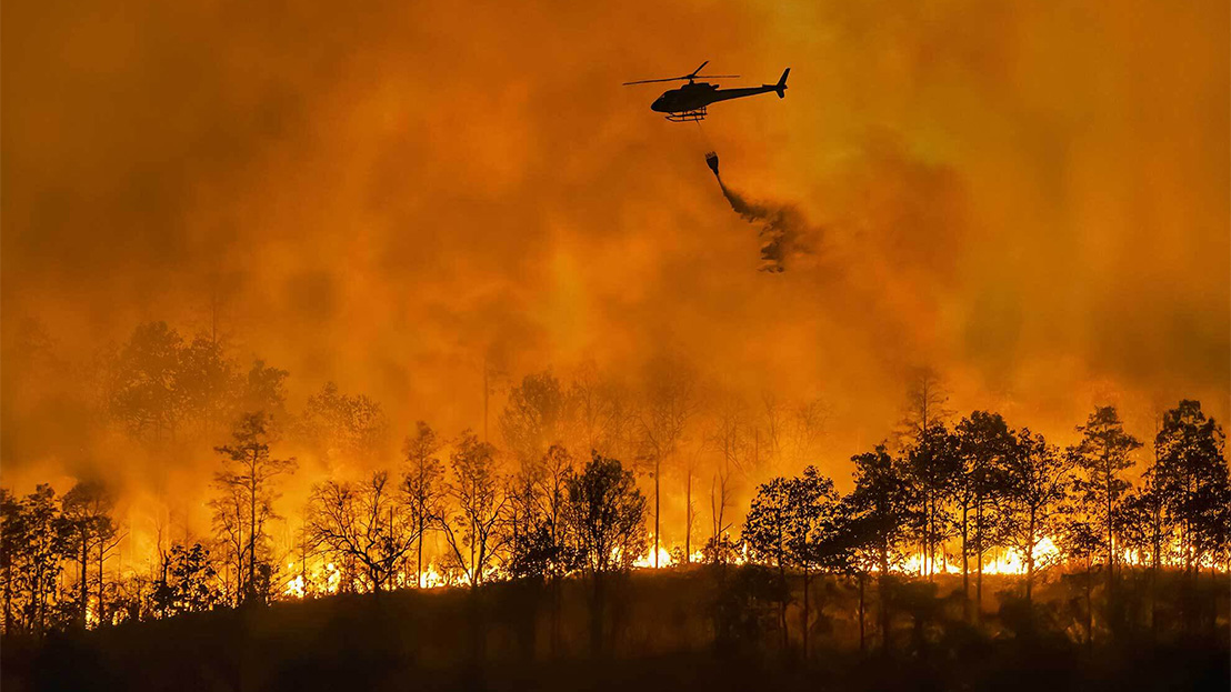 Helicopter dumping water on California wildfire.